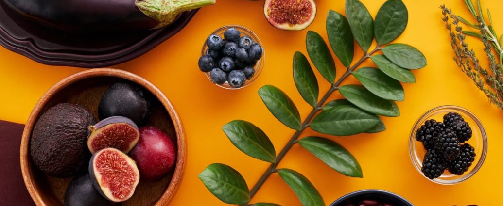 Top view of colorful fruits and vegetables on a vibrant orange background, perfect for healthy lifestyle concepts.
